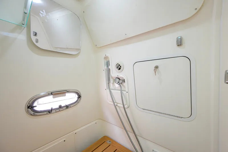 Slide: The Image of Interior of 2018 Boston Whaler 380 Outrage boat, featuring a compact bathroom with shower. - 47