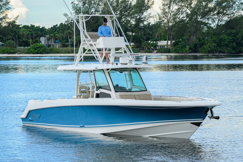 Slide: The Image of 2018 Boston Whaler 380 Outrage boat on calm water, featuring a sleek blue and white design. - 9