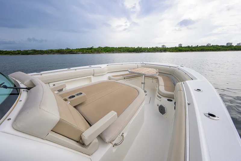 Slide: The Image of 2018 Boston Whaler 380 Outrage boat interior with seating and table on calm water. - 29