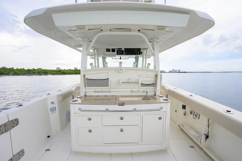 Slide: The Image of 2018 Boston Whaler 380 Outrage boat interior with storage and sink, on calm water. - 1