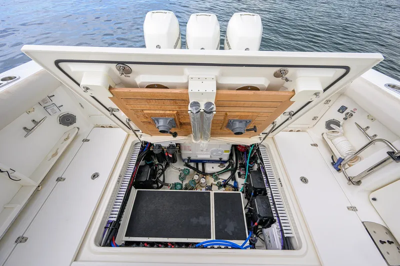 Slide: The Image of 2018 Boston Whaler 380 Outrage engine compartment with open hatch, showcasing mechanical components. - 70
