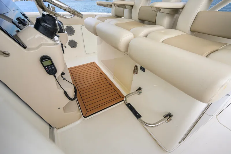 Slide: The Image of 2018 Boston Whaler 380 Outrage helm with beige seating and marine equipment. - 33