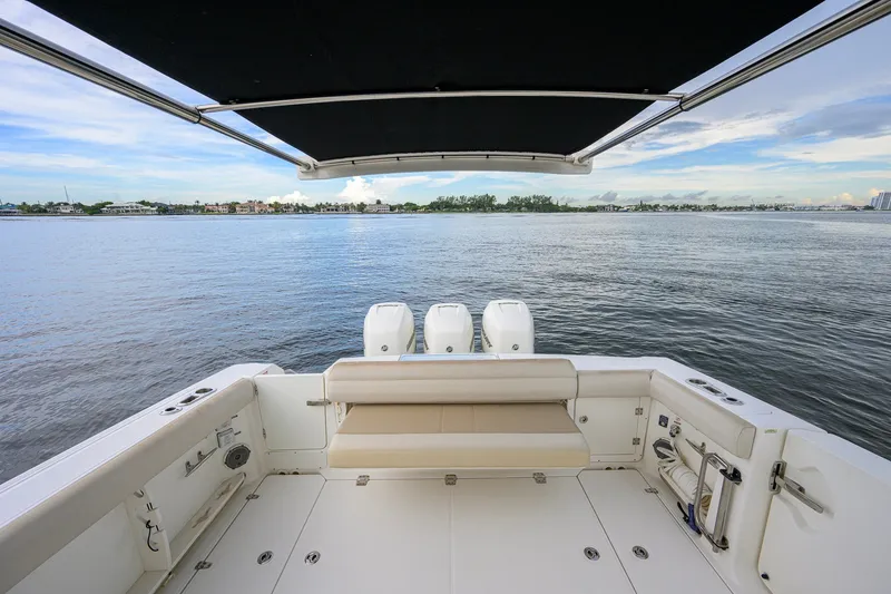 Slide: The Image of 2018 Boston Whaler 380 Outrage boat with triple engines, spacious deck, and scenic water view. - 51