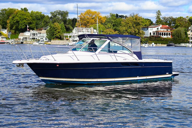 Slide: The Image of 2003 Tiara Yachts 2900 Coronet cruising on a scenic lake with waterfront homes. - 1