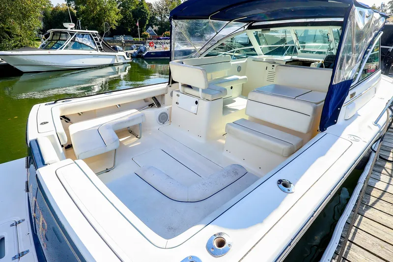 Slide: The Image of 2003 Tiara Yachts 2900 Coronet boat interior with seating and canopy in marina. - 14
