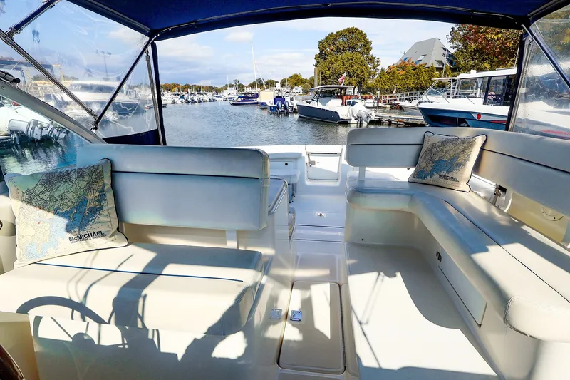 Slide: The Image of 2003 Tiara Yachts 2900 Coronet interior with white seating, docked at a marina. - 11