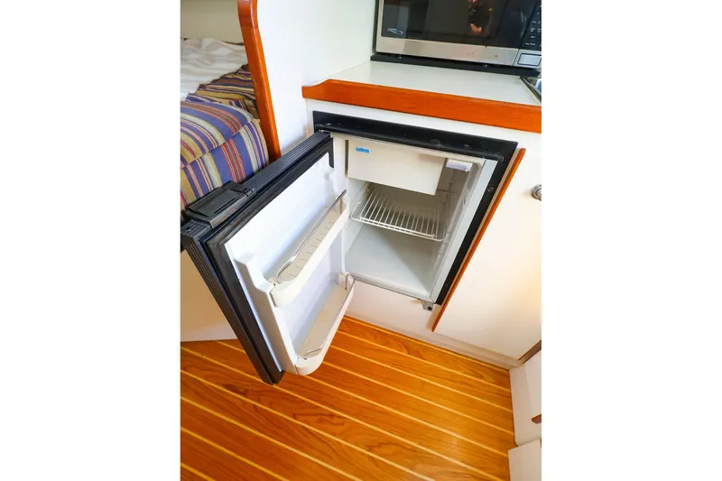 Slide: The Image of Open mini fridge in 2003 Tiara Yachts 2900 Coronet, wooden floor, microwave above. - 27