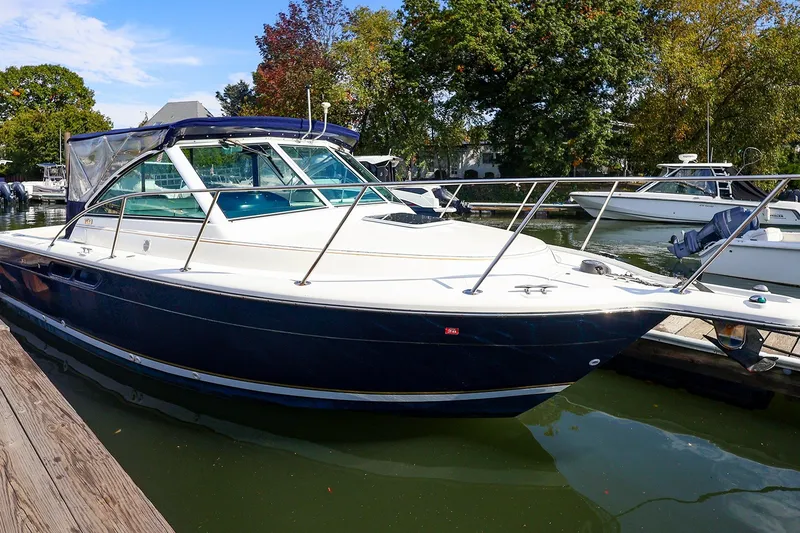Slide: The Image of 2003 Tiara Yachts 2900 Coronet docked, featuring sleek design and blue hull. - 5