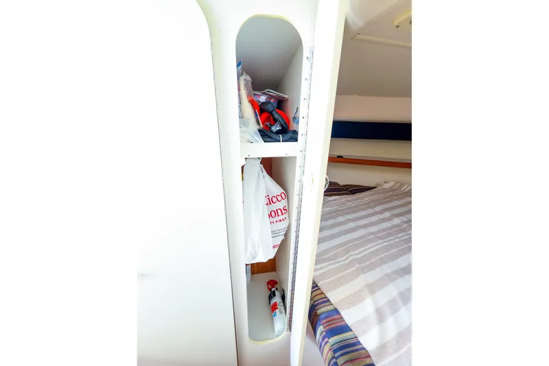 Slide: The Image of 2003 Tiara Yachts 2900 Coronet cabin storage with shelves and bed. - 32