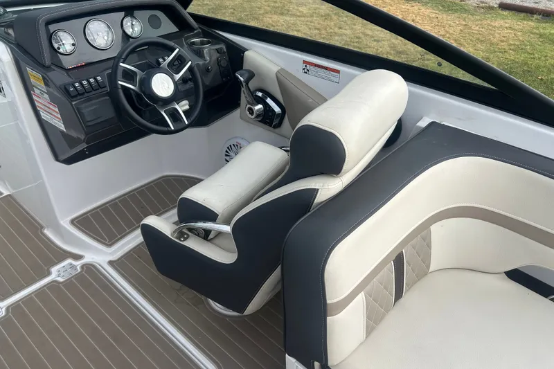 Slide: The Image of 2023 Monterey M6 boat interior with steering wheel and cushioned seating. - 16
