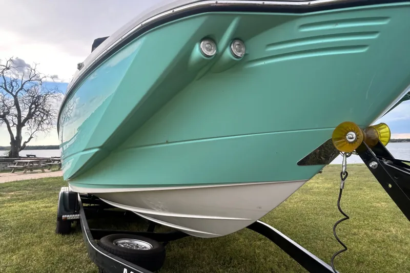 Slide: The Image of 2023 Monterey M6 boat on trailer, parked on grass near a lake. - 5