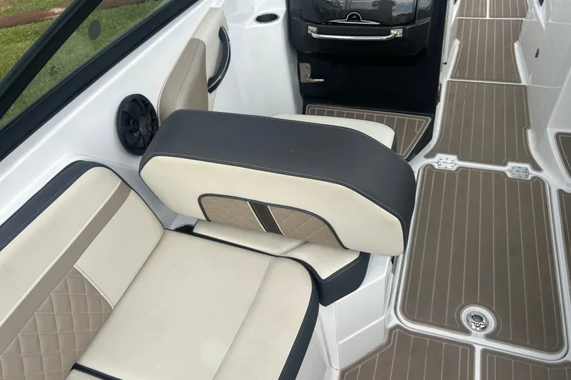 Slide: The Image of 2023 Monterey M6 boat interior with beige and black seating, brown flooring. - 15