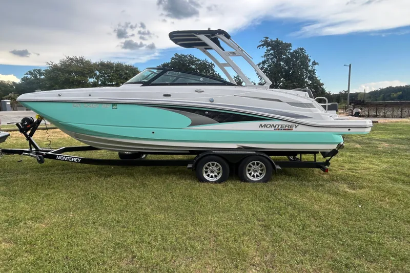 Slide: The Image of 2023 Monterey M6 boat on trailer, parked on grass under cloudy sky. - 3