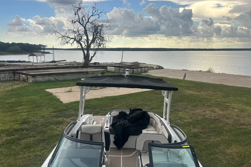 Slide: The Image of 2023 Monterey M6 boat by a serene lake under a cloudy sky. - 9