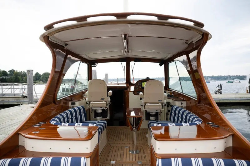 Slide: The Image of 2009 Hinckley Picnic Boat 37 MKIII interior with striped seating and wooden finishes at dock. - 22