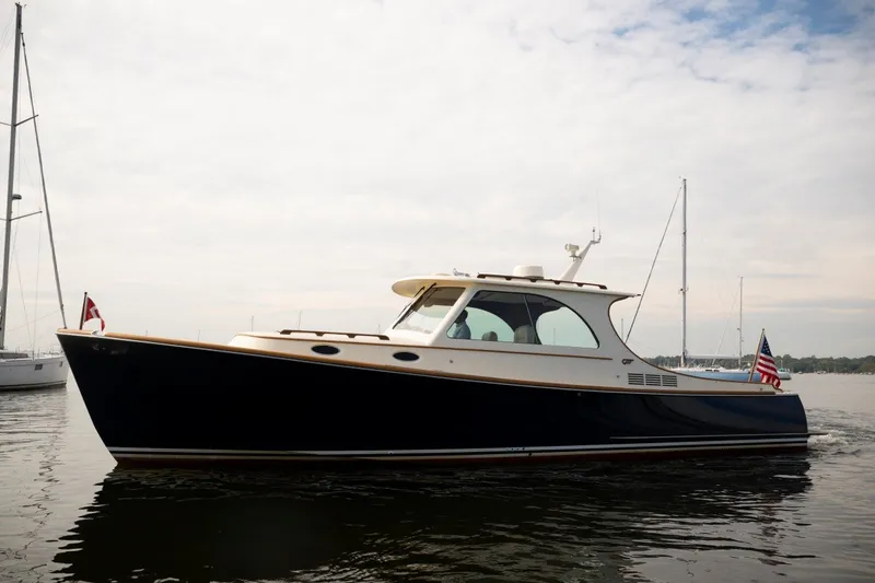The Image of 2009 Hinckley Picnic Boat 37 MKIII cruising on calm waters under a cloudy sky. - 0