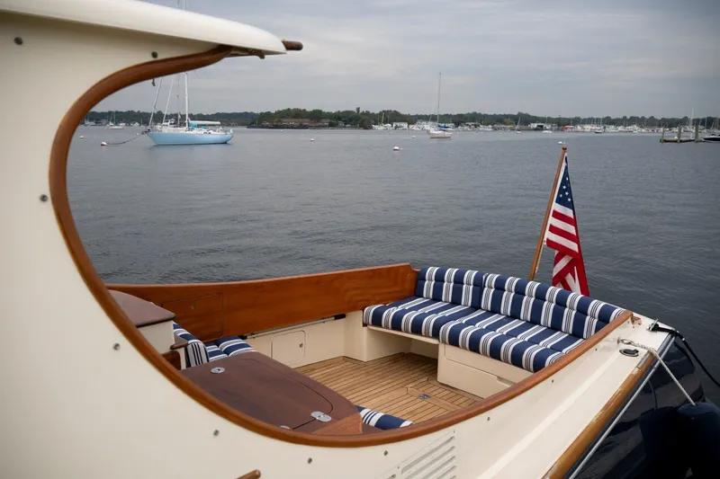 Slide: The Image of Hinckley Picnic Boat 37 MKIII, 2009, with striped seating and American flag, on calm waters. - 21