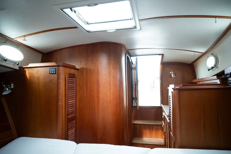Slide: The Image of Interior of 2009 Hinckley Picnic Boat 37 MKIII with wooden cabinetry and natural light. - 16