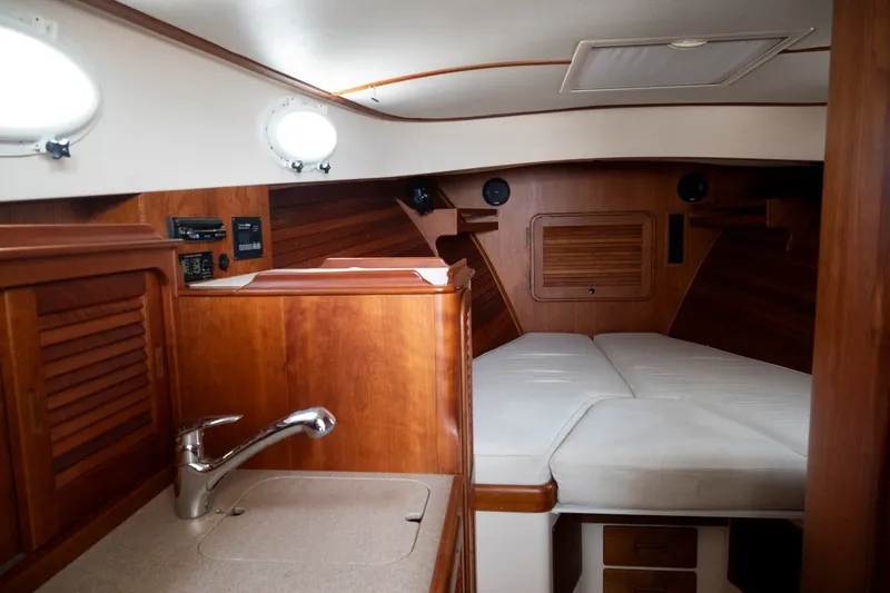 Slide: The Image of 2009 Hinckley Picnic Boat 37 MKIII interior with wood finish and cozy sleeping area. - 15
