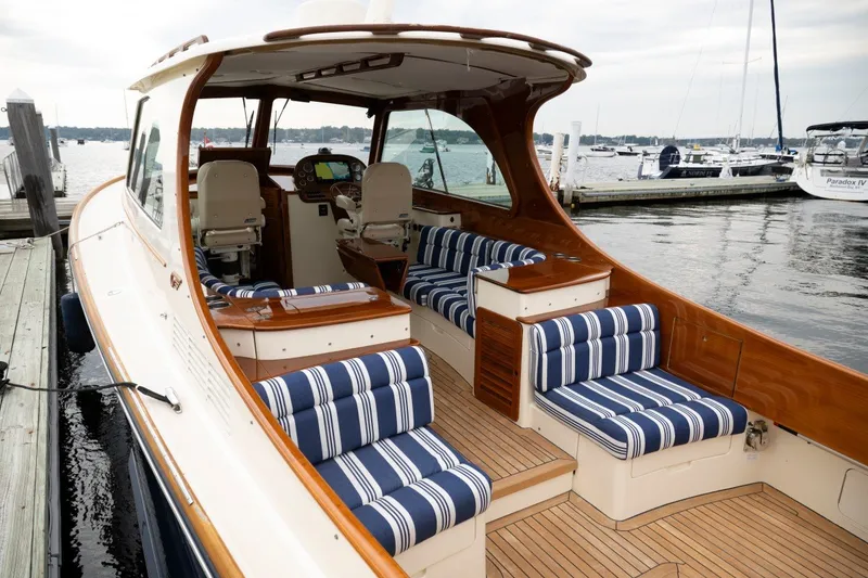 Slide: The Image of Hinckley Picnic Boat 37 MKIII, 2009 model, docked with striped seating and elegant wood finish. - 19