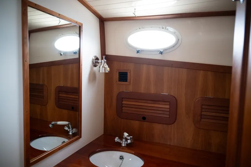 Slide: The Image of Elegant wooden interior of 2009 Hinckley Picnic Boat 37 MKIII bathroom with mirror and sink. - 17