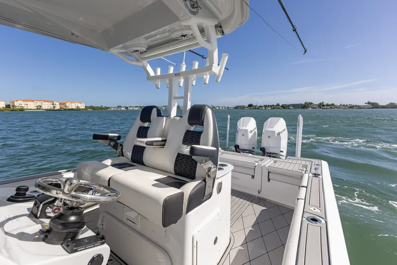 Slide: The Image of 2024 Tidewater 3100 Carolina Bay boat interior with dual engines on open water. - 35