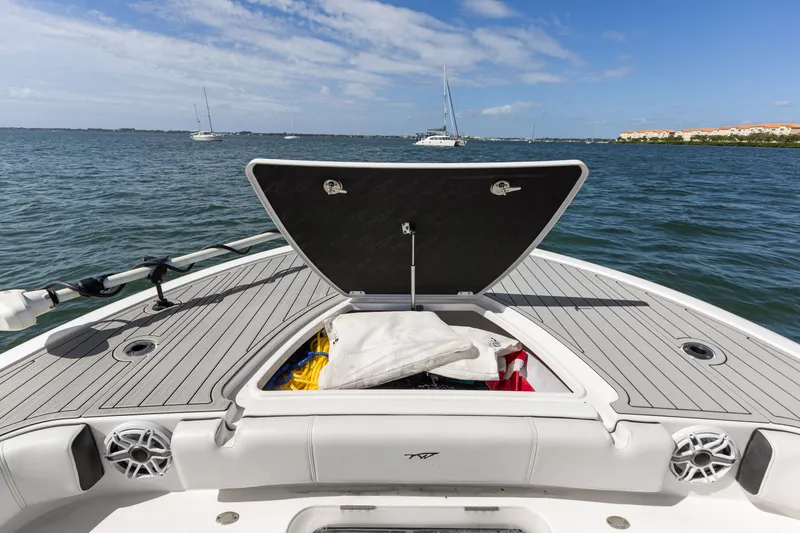 Slide: The Image of 2024 Tidewater 3100 Carolina Bay boat with open storage compartment on calm water. - 47