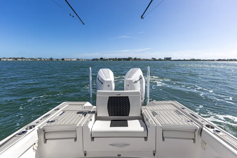 Slide: The Image of 2024 Tidewater 3100 Carolina Bay boat on open water, rear view with twin engines. - 26
