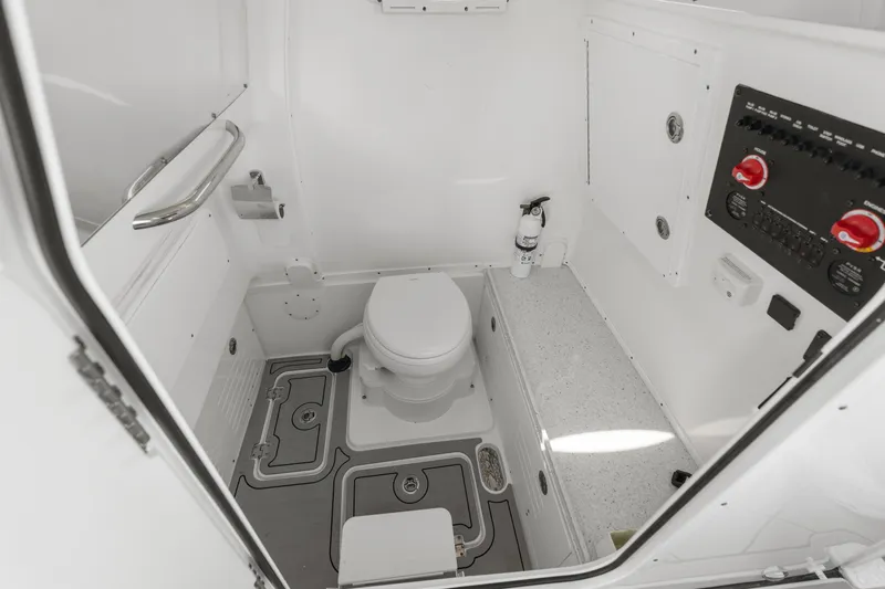 Slide: The Image of 2024 Tidewater 3100 Carolina Bay boat bathroom with toilet and control panel. - 57