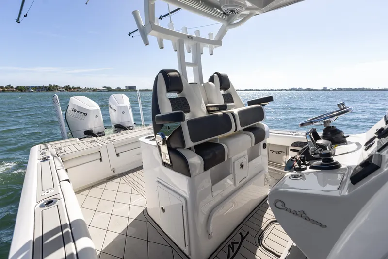 Slide: The Image of 2024 Tidewater 3100 Carolina Bay boat interior with dual engines on open water. - 37