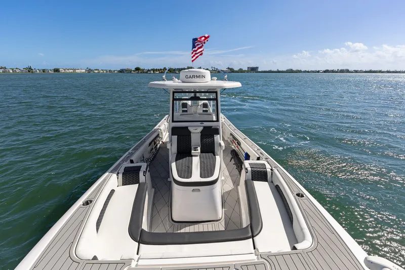Slide: The Image of 2024 Tidewater 3100 Carolina Bay boat on open water, featuring Garmin equipment and American flag. - 51