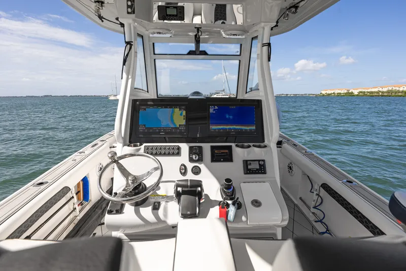 Slide: The Image of 2024 Tidewater 3100 Carolina Bay boat cockpit with advanced navigation systems on open water. - 39