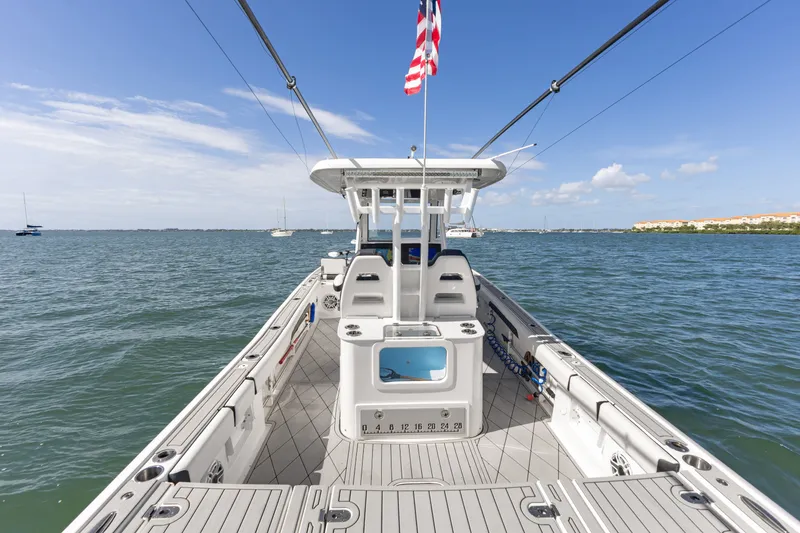 Slide: The Image of 2024 Tidewater 3100 Carolina Bay boat on calm water under clear blue sky. - 29