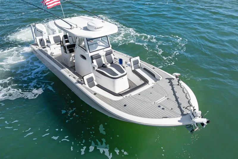 Slide: The Image of 2024 Tidewater 3100 Carolina Bay boat cruising on open water with American flag. - 8