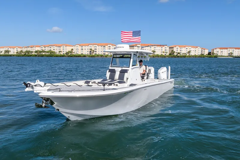 Slide: The Image of 2024 Tidewater 3100 Carolina Bay boat cruising on water with American flag. - 5