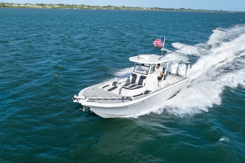 Slide: The Image of 2024 Tidewater 3100 Carolina Bay boat cruising on open water with American flag. - 21
