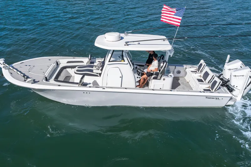 Slide: The Image of 2024 Tidewater 3100 Carolina Bay boat cruising on open water with American flag. - 4
