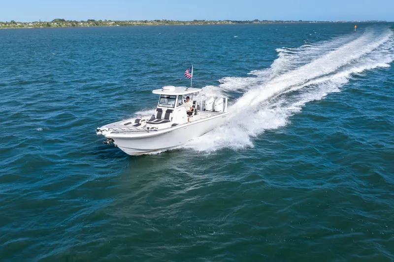 Slide: The Image of 2024 Tidewater 3100 Carolina Bay boat cruising on open water. - 3