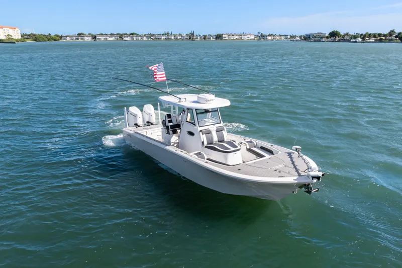 Slide: The Image of 2024 Tidewater 3100 Carolina Bay boat cruising on open water with American flag. - 1