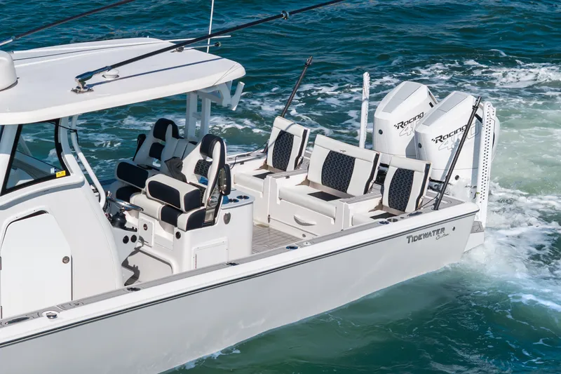Slide: The Image of 2024 Tidewater 3100 Carolina Bay boat cruising on water, featuring dual engines and sleek design. - 14