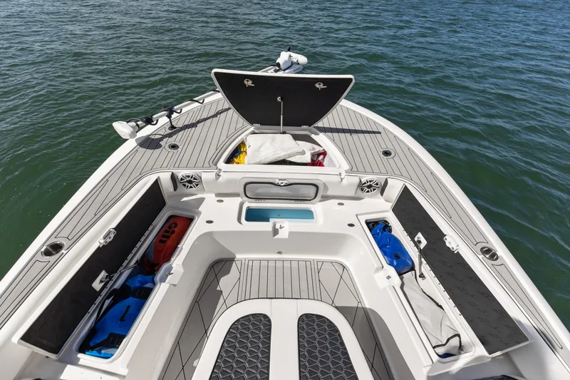 Slide: The Image of 2024 Tidewater 3100 Carolina Bay boat deck with storage compartments open on the water. - 46