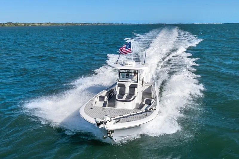 Slide: The Image of 2024 Tidewater 3100 Carolina Bay boat cruising on open water with American flag. - 22