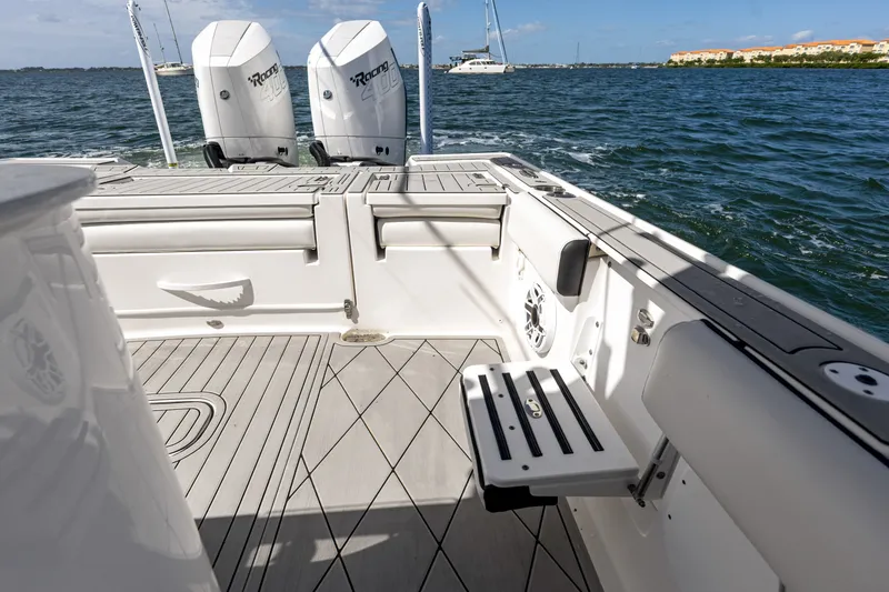 Slide: The Image of 2024 Tidewater 3100 Carolina Bay boat deck with twin outboard motors on water. - 32
