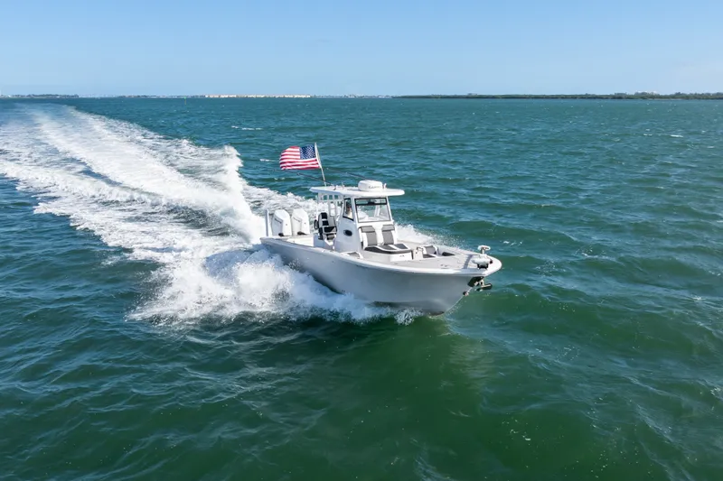 Slide: The Image of 2024 Tidewater 3100 Carolina Bay boat cruising on open water with American flag. - 18