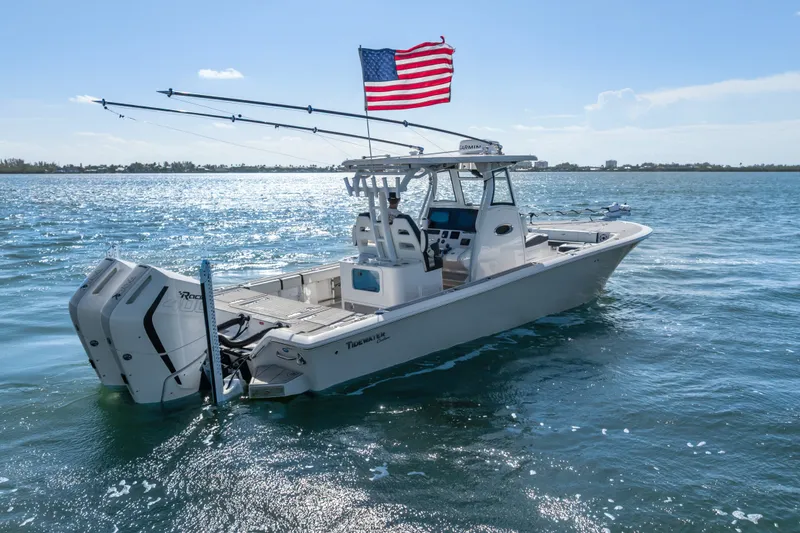 Slide: The Image of 2024 Tidewater 3100 Carolina Bay boat on water with American flag. - 10