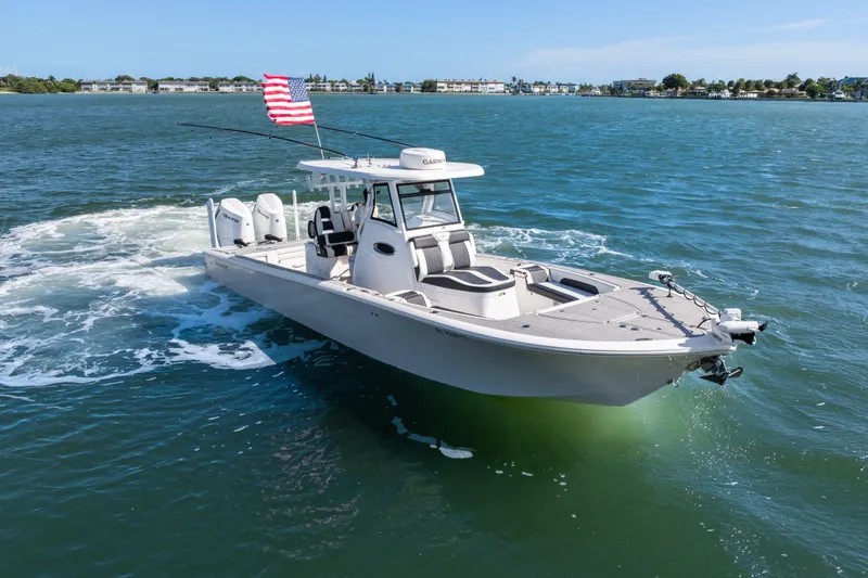 Slide: The Image of 2024 Tidewater 3100 Carolina Bay boat cruising on open water with American flag. - 7