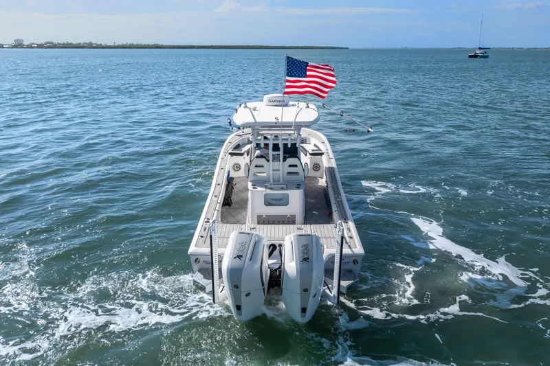 Slide: The Image of 2024 Tidewater 3100 Carolina Bay boat on open water with American flag. - 11