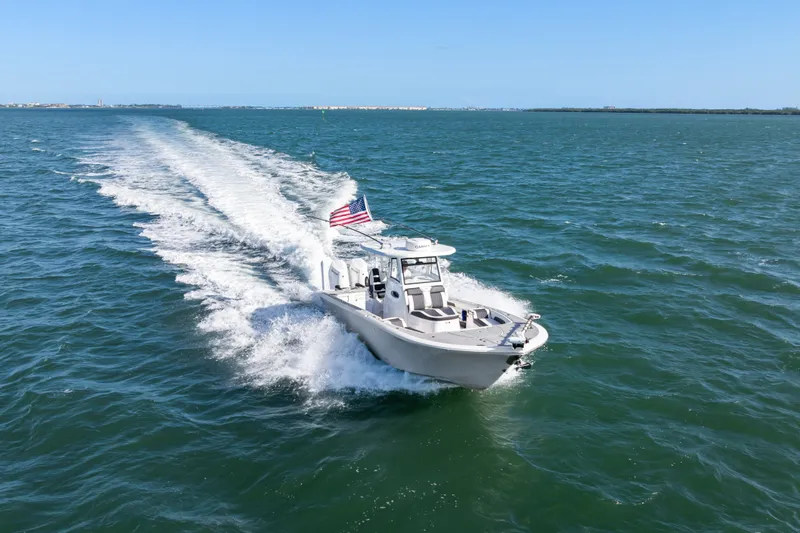 Slide: The Image of 2024 Tidewater 3100 Carolina Bay boat cruising on open water with American flag. - 17
