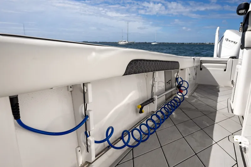 Slide: The Image of 2024 Tidewater 3100 Carolina Bay boat interior with coiled blue hose and ocean backdrop. - 54