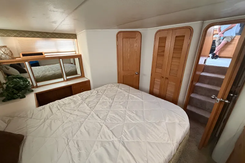 Slide: The Image of Cozy bedroom interior of 1989 Chris-Craft 427 Catalina yacht with wooden accents and mirrored cabinets. - 57